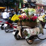 uma bicicleta estacionada na rua com flores em uma cesta no seu topo. ásia é parte de (pop)ulares por Ca Mila.