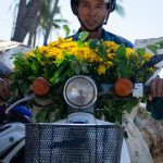 uma pessoa em uma motocicleta transportando flores. ásia é parte de (pop)ulares por Ca Mila.