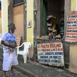 uma pessoa na frente de um comércio. américa é parte da série (pop)ulares por Ca Mila