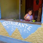 uma criança brincando com flores em um restaurante. américa é parte da série (pop)ulares por Ca Mila