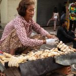 uma vendedora ambulante preparando produtos para a venda. ásia é parte de (pop)ulares por Ca Mila.