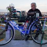 uma pessoa posando para a foto junto com uma bicicleta iluminada por luzes. ásia é parte de (pop)ulares por Ca Mila.