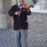 um artista de rua tocando um violino. europa é parte de (pop)ulares por Ca Mila.