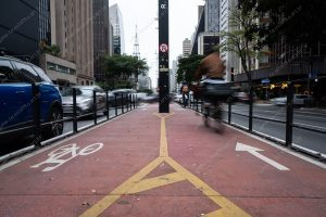 uma pessoa andando de bicicleta na ciclovia. vermelho é parte de outras estórias por Ca Mila