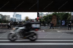 uma motocicleta na faixa de pedestres. vermelho é parte de outras estórias por Ca Mila
