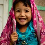 uma criança sorrindo com blusa azul e jaqueta cor-de-rosa. 1,2,3 e... é parte da série emoções por Ca Mila