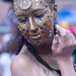 uma mulher com maquiagem dourada e pedrarias olhando para baixo. 1,2,3 e... é parte da série emoções por Ca Mila