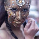 uma mulher com maquiagem dourada e pedrarias olhando para a câmera. 1,2,3 e... é parte da série emoções por Ca Mila