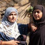 Duas mulheres usando hijab, com roupas azul (esquerda) e marrom (direita) e fazendo pose para a foto. 1,2,3 e... é parte da série emoções por Ca Mila