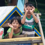 duas pessoas posando para a foto de um barco. sorriso é parte da série emoções por Ca Mila