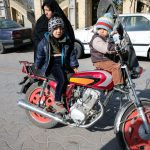 três pessoas, sendo duas crianças em uma motocicleta e uma pessoa atrás. atitude é parte de emoções por Ca Mila