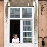 uma pessoa na janela olhando para a lateral. curiosidade é parte de emoções por Ca Mila