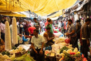 vendedores e compradores num mercado. flores é parte de outras estórias por Ca Mila