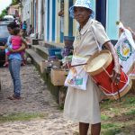 uma pessoa com um tambor na rua. serenidade é parte de emoções por Ca Mila