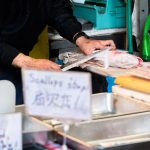 uma pessoa cortando peixe. peixe é parte de outras estórias por Ca Mila